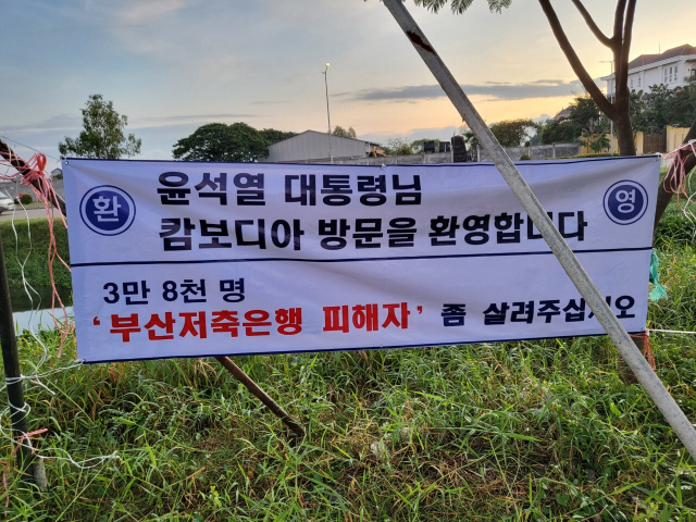 부산저축은행 피해자와 일부 현지 교민들이 캄보디아 수도 프놈펜 인근의 캄코시티 건설 예정지에 윤석열 대통령의 관심을 호소하는 현수막을 내걸었다. 현지 교민 제공.