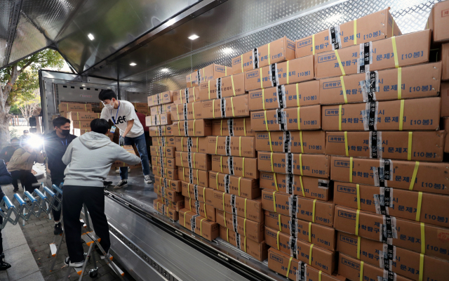 14일 오후 부산 동래구의 한 학교에 도착한 2023학년도 대학수학능력시험 문제지와 답지를 교육청 관계자들이 옮기고 있다. 연합뉴스