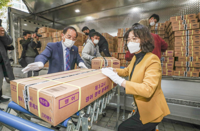 14일 오후 부산의 한 학교에 도착한 2023학년도 대학수학능력시험 문제지와 답안지를 하윤수 부산교육감과 교육청 관계자들이 옮기고 있다. 김종진 기자 kjj1761@