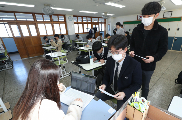 부산진학지원단이 공개한 2023 대입 정시 상담참고표에 따르면 부산대 의예과는 409점이 합격 가능 점수대로 예측됐다. 사진은 지난달 부산의 한 고등학교에서 학생이 수능 가채점 결과를 담임 교사에게 제출하는 모습. 정대현 기자 jhyun@