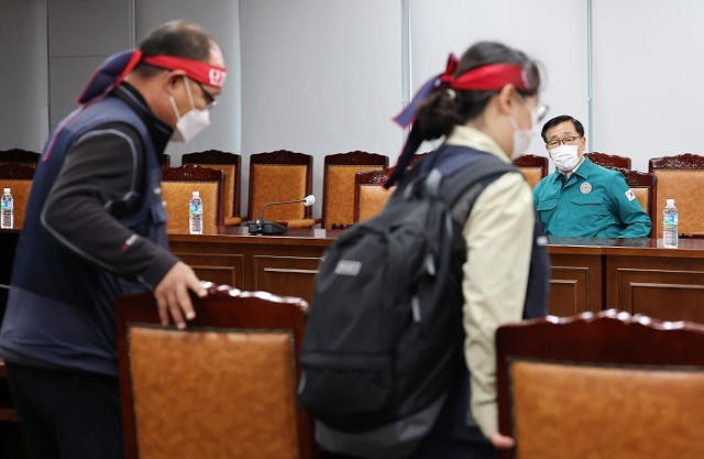 화물연대 관계자들이 28일 오후 세종시 정부세종청사 국토교통부에서 총파업 이후 첫 교섭을 위해 자리에 앉고 있다. 오른쪽은 어명소 국토교통부 제2차관. 연합뉴스