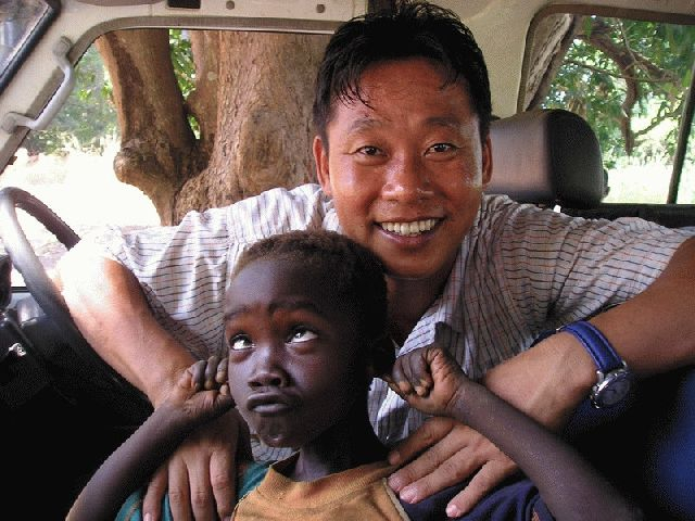 2004년 수단에서 즐거운 표정으로 한 아이와 장난을 치고 있는 이태석 신부. 부산일보DB