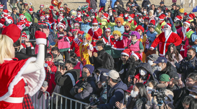 24일 부산 해운대해수욕장에서 열린 부산일보사 주최 ‘제35회 해운대북극곰축제’에서 크리스마스 컨셉의 이색적인 옷차림을 한 참가자들이 축하가수의 공연을 보며 즐거워하고 있다.