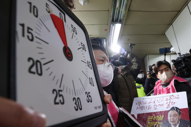 전국장애인차별철폐연대(전장연) 회원들이 2일 오전 서울 지하철 4호선 삼각지역 승강장에서 5분이 표시된 시계를 들고 지하철 탑승을 시도하고 있다. 서울중앙지법은 지난달 19일 서울교통공사가 전장연과 이 단체 박경석 대표 등을 상대로 낸 손해배상 소송을 강제조정하며 전장연이 지하철 승하차 시위로 5분을 초과해 지하철 운행을 지연시키면 1회당 500만원을 공사에 지급하도록 했다. 연합뉴스