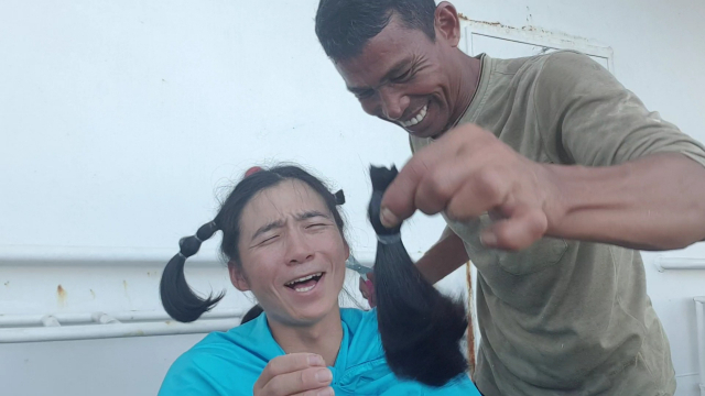 김현무 항해사의 길게 기른 머리카락을 동료 선원이 잘라주는 모습. 자른 머리는 소아암 환자를 위해 기부했다. 김현무 항해사 제공