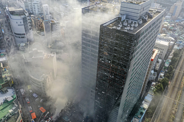 지난 9일 오전 부산진구 한 오피스텔 주차타워에서 불이 나 연기로 뒤덮혀 있다. 김종진 기자 kjj1761@