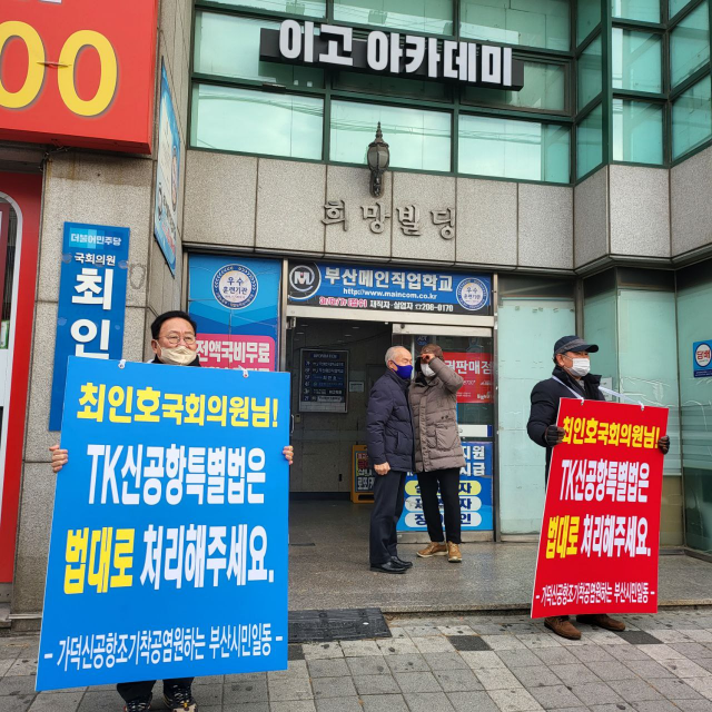 TK정치권이 TK신공항 특별법 처리를 서두르면서 부산 지역 국회의원들의 대응에 관심이 쏠리고 있다. 사진은 가덕신공항 조기착공 국민행동본부 회원들이 지난 26일 더불어민주당 최인호 의원 지역 사무실 앞에서 지원 최 의원을 지원하는 피켓 응원을 하는 모습. 가덕신공항 조기착공 국민행동본부 제공.