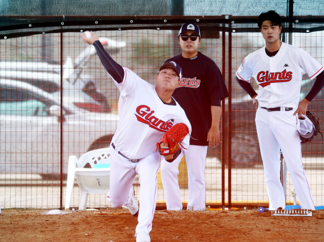 롯데 자이언츠 투수 나균안이 2일 해외 스프링캠프가 진행 중인 괌 데데도스포츠컴플렉스에서 배영수 코치(가운데)가 지켜보는 가운데 불펜 투구를 하고 있다. 괌(미국)=정종회 기자 jjh@
