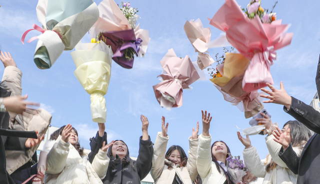 7일 부산 연제구 이사벨고등학교 제56회 졸업식에서 졸업생들이 꽃다발을 높이 던지며 졸업을 축하하고 있다.