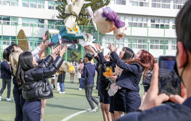 7일 부산 연제구 이사벨고등학교 제56회 졸업식에서 졸업생들이 꽃다발을 높이 던지며 졸업을 축하하고 있다.