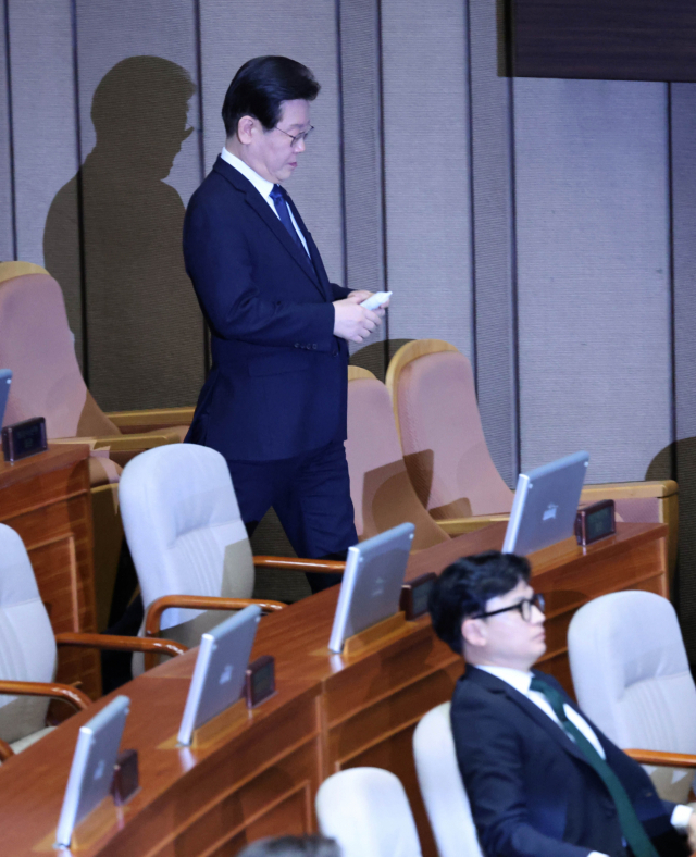 더불어민주당 이재명 대표가 27일 국회에서 열린 본회의에서 본인의 체포동의안에 관해 투표를 마친 뒤 투표용지를 투표함에 넣기 위해 이동하며 한동훈 법무부 장관 옆을 지나고 있다. 연합뉴스