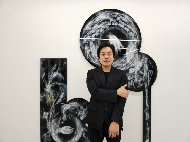 정안용 작가가 연기 이미지를 이용한 작품 '몸' 앞에 서 있다. 오금아 기자