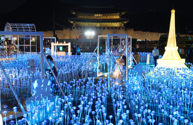 30일 오후 서울 종로구 광화문 광장에 마련된 2030 부산세계박람회(EXPO) 유치 기원 점등식을 찾은 시민들이 불 밝힌 LED 장미를 살펴보고 있다. 연합뉴스
