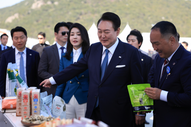 윤석열 대통령과 김건희 여사가 31일 경상남도 통영시 영운항에서 열린 제12회 수산인의 날 기념식에서 수산물 홍보 부스를 방문하고 있다. 연합뉴스