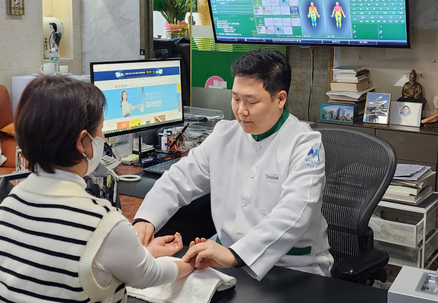 HK한국한의원 윤태관 검진원장이 갱년기 증상 환자를 진료하고 있다. HK한국한의원 제공