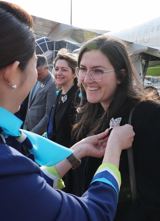 에어부산 승무원들이 실사단에 오미자 브로치를 달아주고 있다. 오미자의 꽃말은 '다시 만나요'다. 정종회 기자 jjh@
