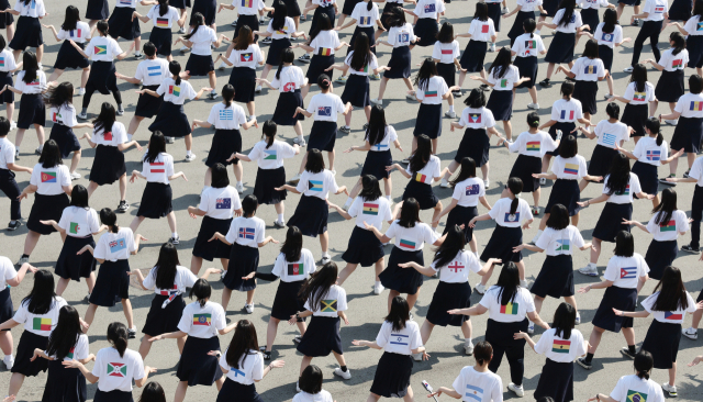 2030부산월드엑스포 유치 협력학교로 선정된 남성여고 학생들이 7일 오후 부산 중구 용두산공원에서 세계 각국의 국기가 새겨진 옷을 입고 ‘더불어 살기 위한 나눔’을 주제로 플래시몹을 하고 있다. 정종회 기자 jjh@