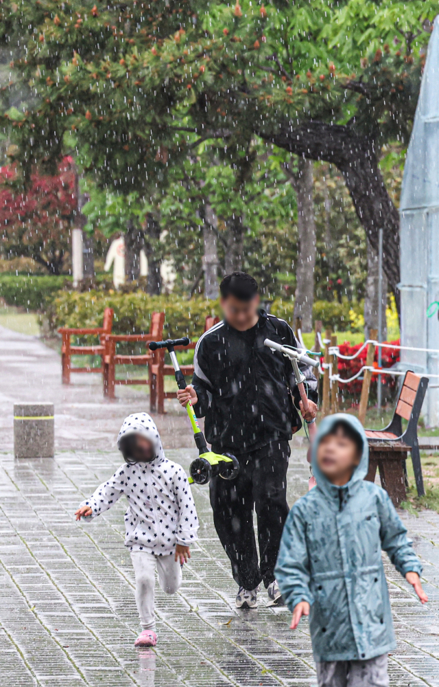 16일 오후 부산시민공원에서 갑작스레 쏟아진 우박에 시민들이 발걸음을 재촉하고 있다. 김종진 기자 kjj1761@