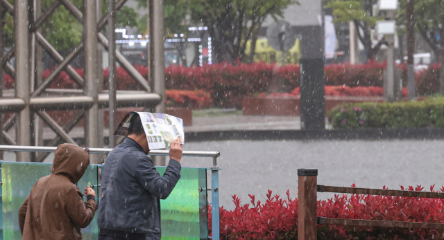 16일 오후 부산시민공원에서 갑작스레 쏟아진 우박에 시민들이 발걸음을 재촉하고 있다. 김종진 기자 kjj1761@
