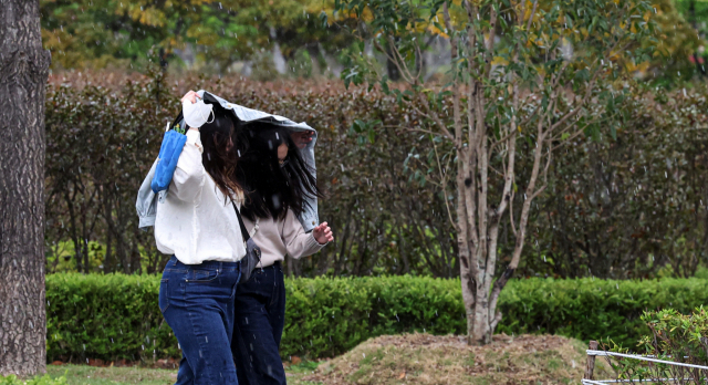 16일 오후 부산시민공원에서 갑작스레 쏟아진 우박에 시민들이 발걸음을 재촉하고 있다. 김종진 기자 kjj1761@