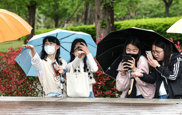16일 오후 부산시민공원에서 갑작스레 우박이 쏟아지자 아이들이 처음보는 우박을 신기한듯 살펴보고 있다. 김종진 기자 kjj1761@