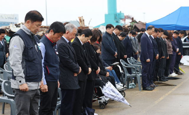 세월호 참사 9주기를 맞은 16일 세월호 선체가 거치된 전남 목포시 목포신항에서 '세월호 참사 9주기 기억식'에 참석한 시민들이 묵념을 하고 있다.연합뉴스