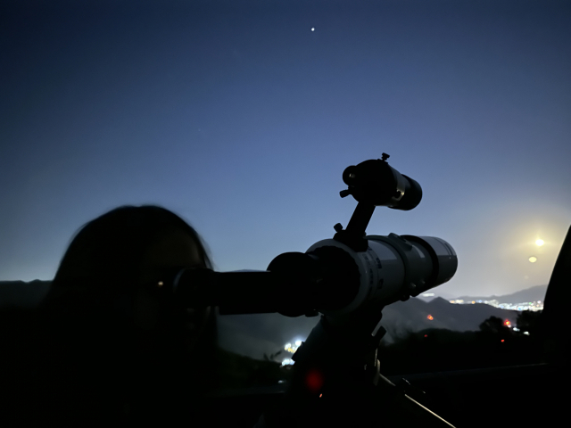 보조관측실에서 한 어린이가 소형 천체망원경으로 달을 관찰하고 있다.