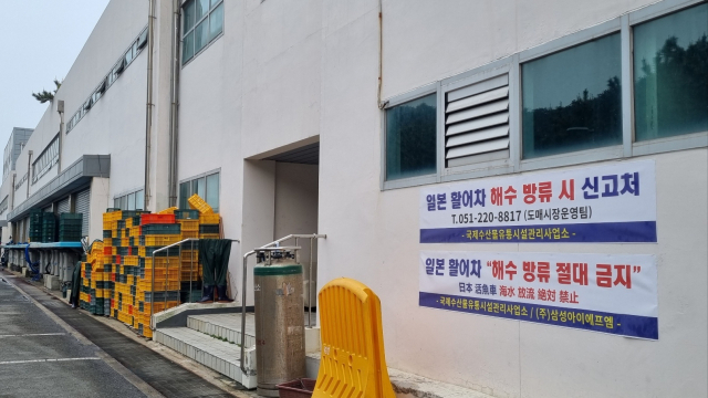 지난 21일 오전 부산 서구 암남동 부산국제수산물 도매시장 활어 보세창고 앞에 붙은 안내문. 일본 활어차가 싣고 온 해수를 무단으로 방류하지 말라는 문구가 한글과 일본어로 병기돼 있다. 박혜랑 기자 rang@