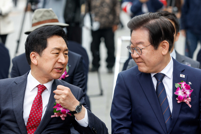 국민의힘 김기현(왼쪽) 대표와 더불어민주당 이재명 대표가 20일 서울 종로구 광화문광장에서 열린 제59회 한국보도사진전 개막식에서 대화하고 있다. 사진공동취재단