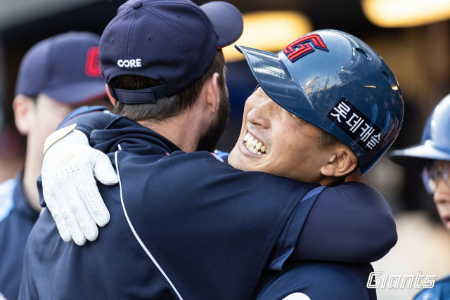 롯데 자이언츠 외야수 안권수가 지난 22일 NC와의 경기에서 프로 첫 홈런을 터뜨린 뒤 더그아웃에서 렉스에게 축하 인사를 받고 있다. 롯데 자이언츠 제공