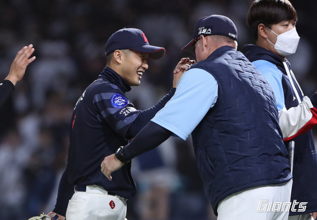 롯데 자이언츠 외야수 안권수가 지난 22일 NC 다이노스와의 경기에서 승리한 뒤 롯데 래리 서튼 감독과 하이파이브를 하며 더그아웃으로 들어가고 있다. 롯데 자이언츠 제공
