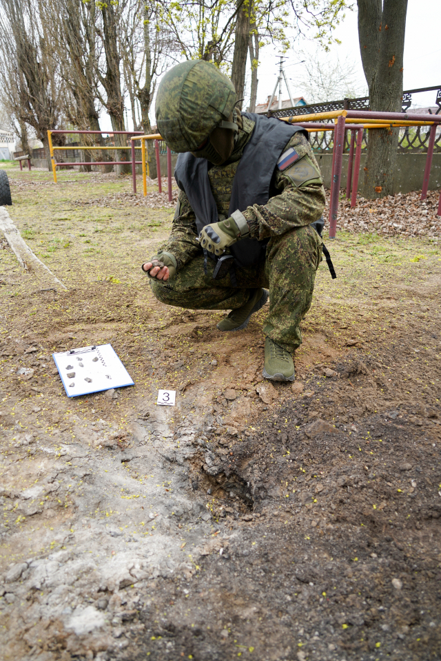 지난 14일 러시아 군인이 헤르손주 한 중학교에서 박격포탄 낙하 지점을 조사 중이다. 타스연합뉴스