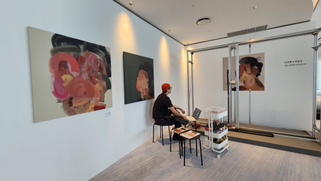 신교명 작가가 로봇 이일오를 이용해서 그림을 그리고 있다. 오금아 기자