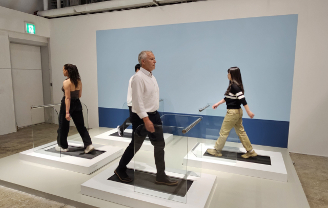 줄리안 오피(제일 앞) 작가가 3일 부산 개인전 기자간담회에서 퍼포먼스 작품을 시연하고 있다. 이 작품은 부산의 바다를 배경으로 걷는 사람들을 표현한 것으로 관람객이 참여할 수 있다. 오금아 기자