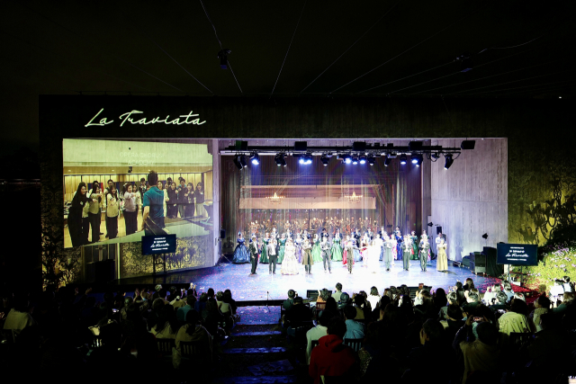 오페라 '라 트라비아타' 커튼콜 장면. 왼쪽 대형 화면에는 부산 지역 청년 오페라 인재를 위한 인큐베이팅 프로그램으로 도입한 '오페라 합창단 아카데미' 연습 장면이 나오고 있다. 문화재단1963 제공