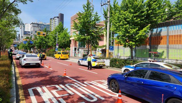 어린이보호구역에서 어린이 통행을 방해하는 주정차는 전면 금지된다. 경찰 단속 중인 부산의 한 어린이보호구역. 부산경찰청 제공