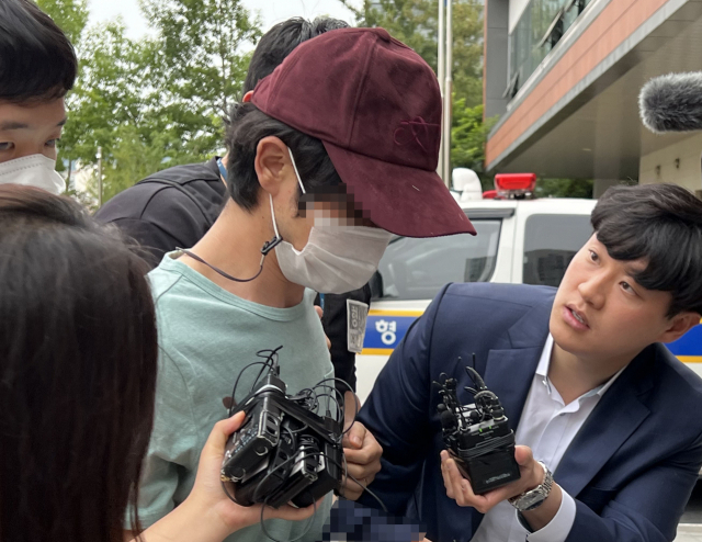 데이트 폭력으로 신고당해 경찰 조사를 받은 뒤 애인을 살해한 혐의를 받는 김 모(33) 씨가 26일 오후 경찰에 긴급체포된 후 서울 금천경찰서에 들어서고 있다. 연합뉴스