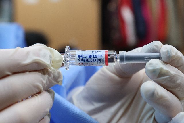 의료진이 독감 백신을 들어올려 보이고 있다. 연합뉴스