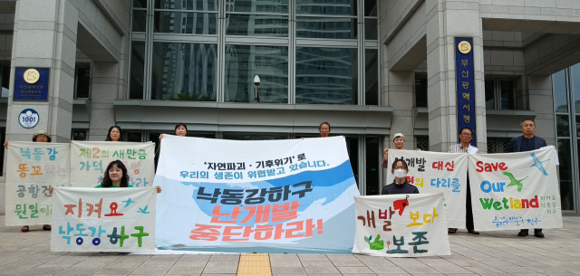 낙동강하구지키기전국시민행동 등 환경단체가 5일 오전 세계 환경의 날을 맞아 부산 시청 앞에서 낙동강 하구 난개발 저지를 위한 퍼포먼스를 벌이고 있다. 낙동강하구지키기전국시민행동 제공