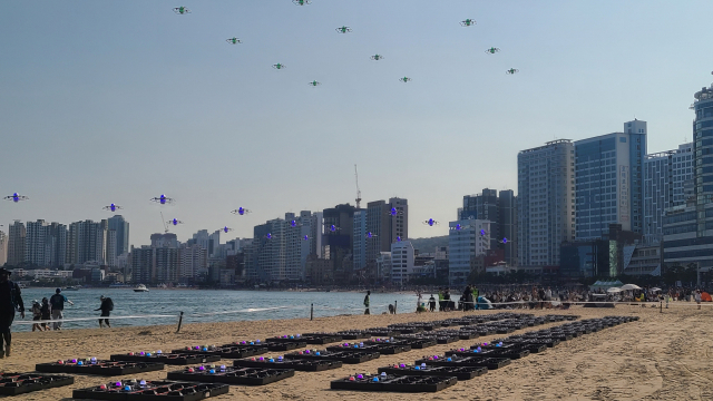 일정한 간격을 두고 배치된 드론들이 시험 비행을 위해 떠오르는 모습.