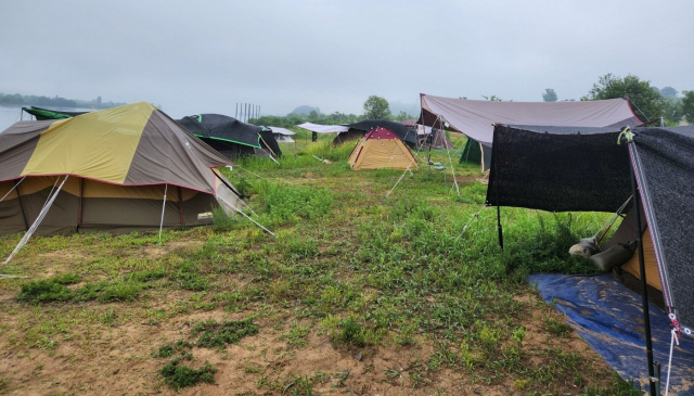 경남 창원시 본포수변생태공원에서 기승을 부리던 일명 ‘알박기 텐트’가 철퇴를 맞는다. 오는 7월 1일부터 야영·취사 금지를 알리는 플래카드(위)와 ‘알박기 텐트’가 가득 찬 본포수변생태공원. 강대한 기자 kdh@