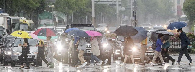지난해 장마철에 부산 동래구에서 시민들이 우산을 쓰고 길을 건너는 모습. 부산일보DB
