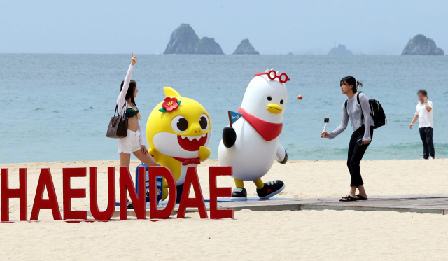 부산 해운대해수욕장에 설치된 ‘핑크퐁 아기상어’와 부산시 홍보 캐릭터 ‘부기’ 조형물. 부산일보DB