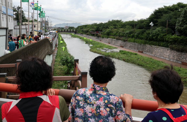 경찰관과 소방관들이 12일 오전 부산 사상구 학장천에서 지난 11일 폭우로 물이 불어나는 바람에 물길에 휩쓸린 60대 실종자 수색작업을 벌이고 있다. 정종회 기자 jjh@