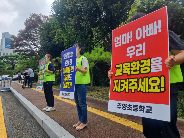 19일 오후 1시 30분께 부산시교육청 앞에서 주양초등 교사와 학부모들이 인근 28층 아파트 건립을 반대하며 피켓 시위를 벌였다. 손혜림 기자 hyerimsn@