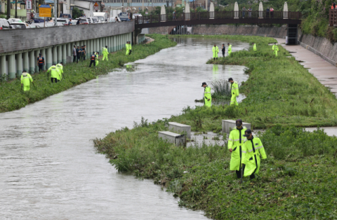 12일 오전 부산 사상구 학장천에서 경찰과 소방 인력이 지난 11일 폭우로 학장천의 물이 불어나면서 실종된 60대 시민 수색 작업을 하고 있다. 정종회 기자 jjh@