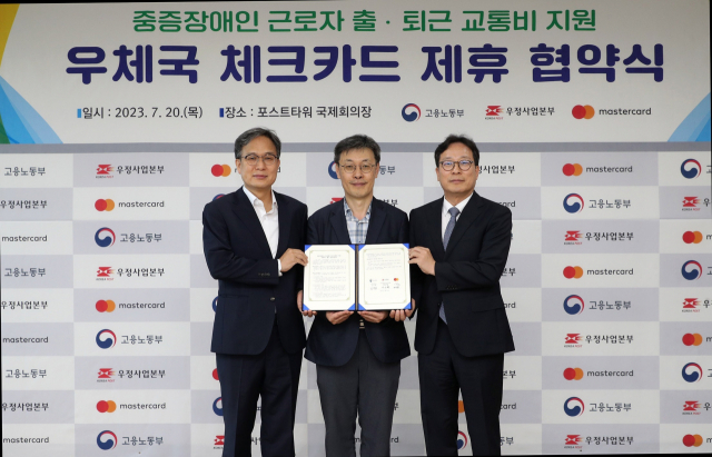 20일 서울중앙우체국 국제회의장에서 열린 ‘중증장애인 근로자 출·퇴근 교통비 지원 전용카드 신규출시 업무협약식’에 참석한 박인환 우정사업본부장 직무대리(오른쪽)와 김성호 고용노동부 고용정책실장(가운데), 이태형 마스터카드 코리아 부사장이 기념촬영을 하고 있다. 우정사업본부 제공