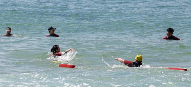 올 부산지역 해수욕장에서 입수시간 후 바다에 들어가는 등 이용객의 안전불감증이 만연하다는 지적이 나온다. 해운대해수욕장에서 민간수상구조대원들이 인명구조훈련하는 모습. 부산일보DB
