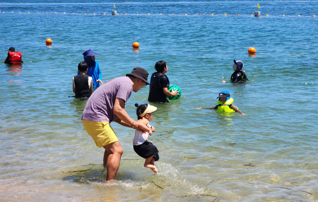 6일 오전 울산 동구 일산해수욕장에서 한 시민이 아이와 물놀이하고 있다. 연합뉴스