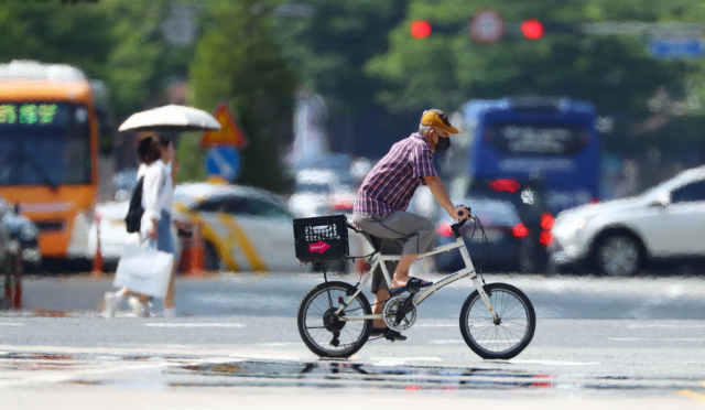 70대 이상 고령층 온열질환자 발생이 늘어나자 부산시가 시내 모든 경로당을 무더위 쉼터로 개방한다. 폭염 경보가 내려진 지난달 31일 오후 부산 해운대구 벡스코 인근 도로에서 시민들이 지열로 이글거리는 횡단보도를 건너고 있다. 정종회 기자 jjh@